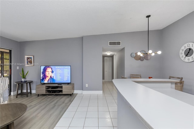 9660 S Belfort Cir Unit 207, Tamarac, FL 33321 - living area with baseboards, a chandelier, and light wood finished floors