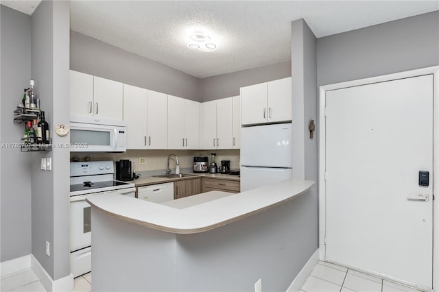 9660 S Belfort Cir Unit 207, Tamarac, FL 33321 - kitchen with white appliances, a sink, baseboards, a textured ceiling, and a peninsula