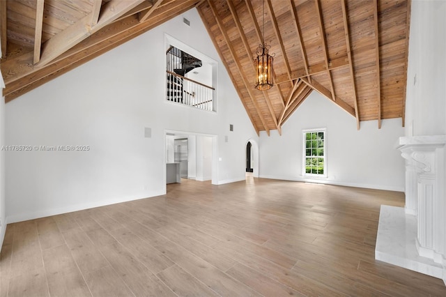 6320 Hancock Rd, Southwest Ranches, FL 33330 - unfurnished living room with a chandelier, a wooden ceiling with exposed beams, arched walkways, wood finished floors, and high vaulted ceiling