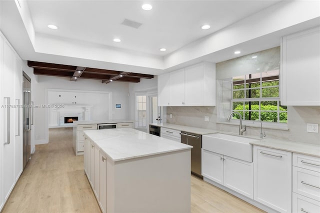 6320 Hancock Rd, Southwest Ranches, FL 33330 - kitchen with a kitchen island, stainless steel dishwasher, backsplash, light wood finished floors, and white cabinetry