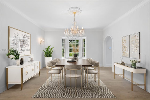 6320 Hancock Rd, Southwest Ranches, FL 33330 - dining space with arched walkways, crown molding, a chandelier, and light wood-style floors