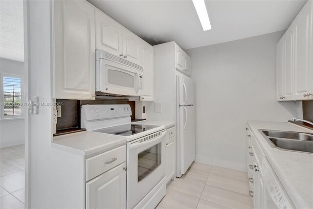 kitchen featuring light countertops, white cabinetry, a sink, and white appliances