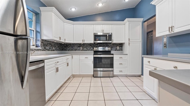 5010 SW 201st Ter, Southwest Ranches, FL 33332 - kitchen with appliances with stainless steel finishes, vaulted ceiling, backsplash, light countertops, and white cabinetry