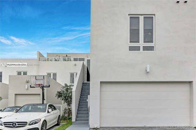 10550 NW 63rd Ter, Doral, FL 33178 - view of front of home featuring stucco siding, an attached garage, and stairway