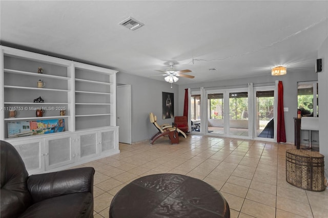living room featuring plenty of natural light, visible vents, light tile patterned floors, and ceiling fan