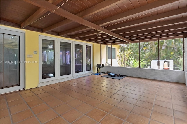 unfurnished sunroom featuring beam ceiling