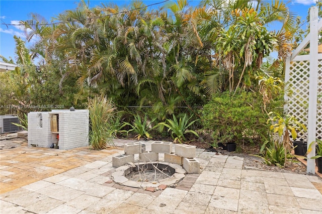 view of patio / terrace featuring fence, a fire pit, and cooling unit
