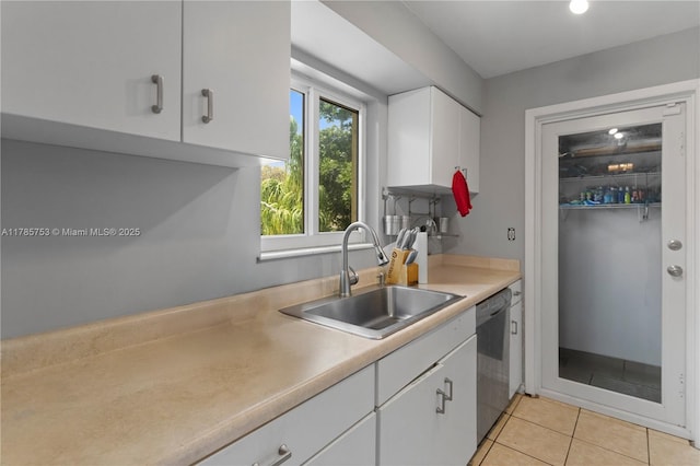 kitchen featuring light countertops, a sink, white cabinetry, dishwasher, and light tile patterned floors