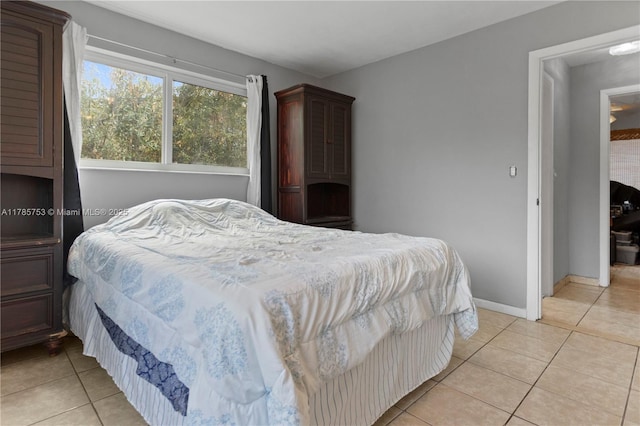 bedroom with baseboards and light tile patterned floors