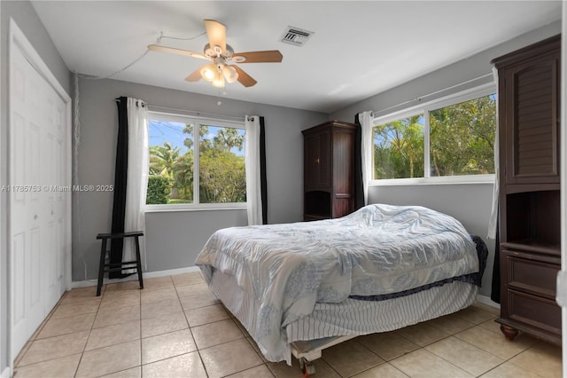 bedroom featuring baseboards, multiple windows, visible vents, and light tile patterned floors
