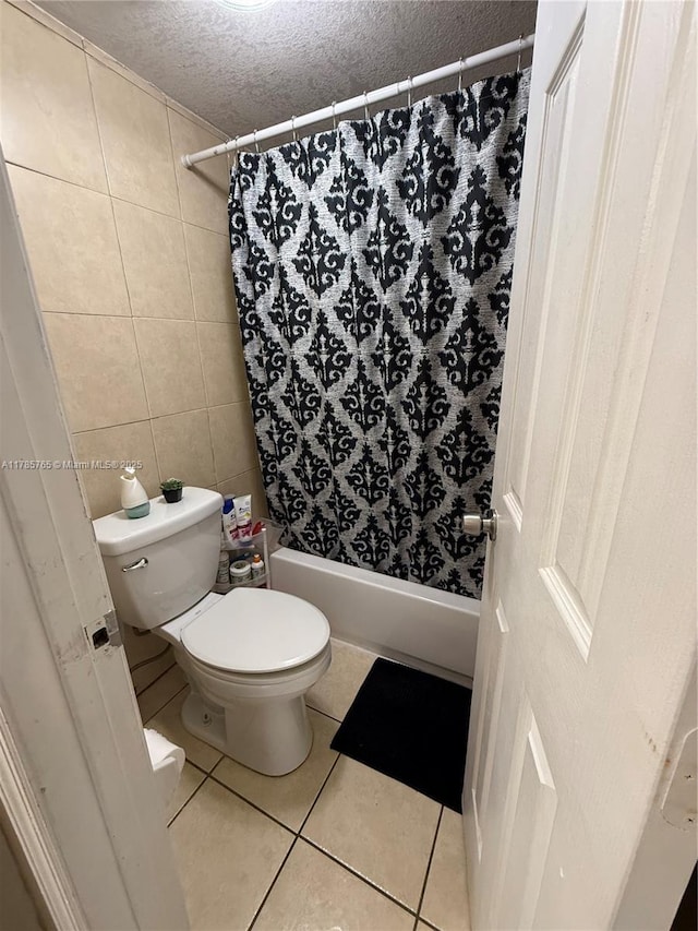 bathroom featuring a textured ceiling, shower / bath combo, toilet, tile walls, and tile patterned floors