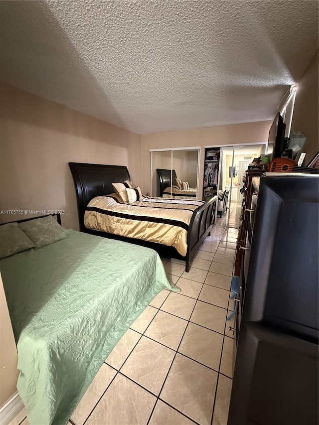 bedroom featuring a textured ceiling and light tile patterned flooring