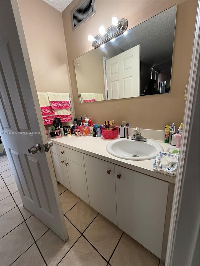 bathroom with vanity, a textured ceiling, visible vents, and tile patterned floors