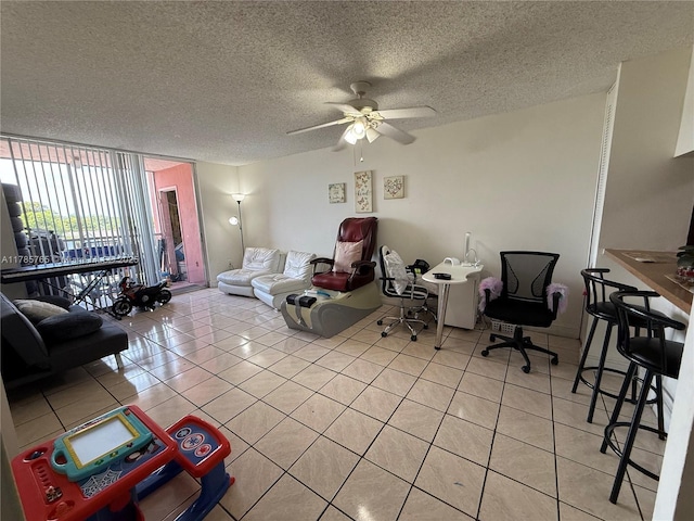 living area with light tile patterned floors, a ceiling fan, and a textured ceiling