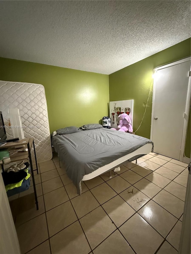 bedroom with a textured ceiling and tile patterned flooring