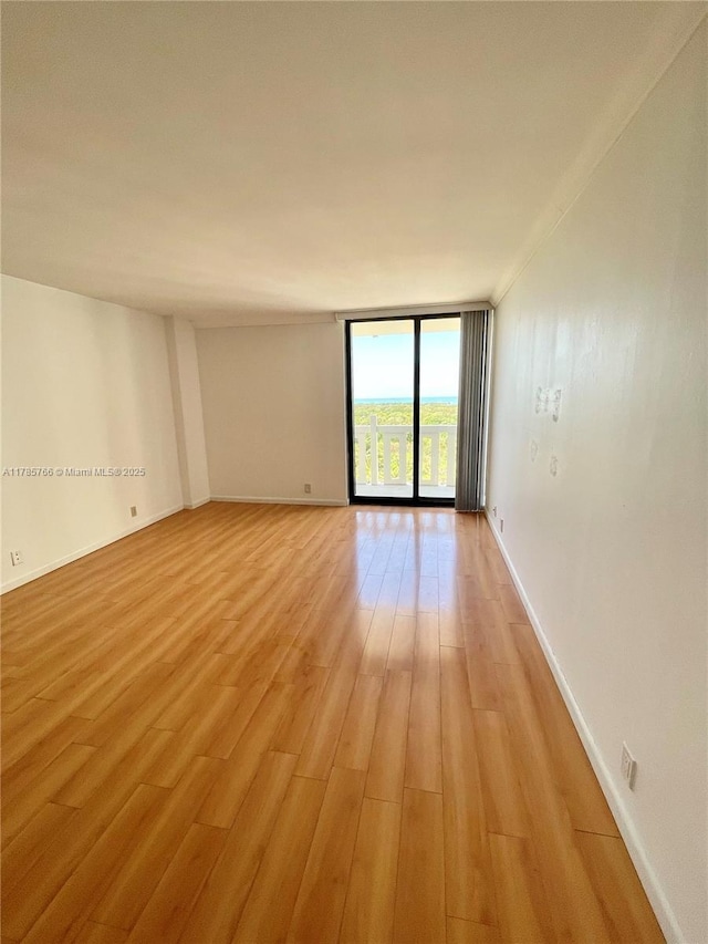 1111 Crandon Blvd Unit B804, Key Biscayne, FL 33149 - empty room featuring baseboards, expansive windows, and light wood-type flooring