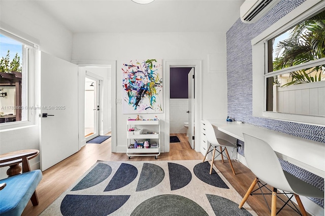 office space featuring light wood finished floors and built in desk