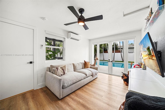 living area featuring a wealth of natural light, french doors, wood finished floors, and a wall mounted AC