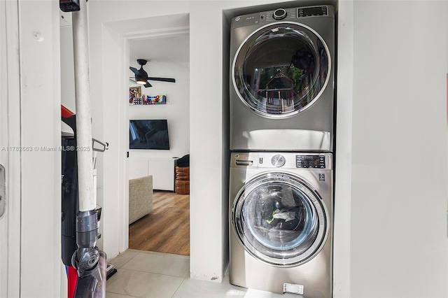 laundry area featuring tile patterned flooring, ceiling fan, stacked washer / drying machine, and laundry area