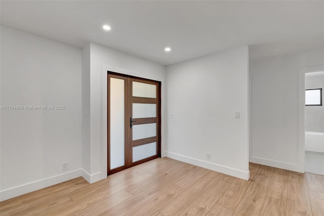 unfurnished room featuring recessed lighting, light wood finished floors, and baseboards
