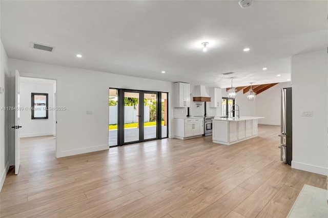 unfurnished living room featuring a sink, baseboards, visible vents, recessed lighting, and light wood-style floors