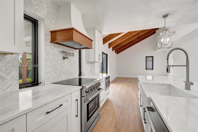 kitchen with vaulted ceiling with beams, custom exhaust hood, white cabinetry, decorative backsplash, and appliances with stainless steel finishes