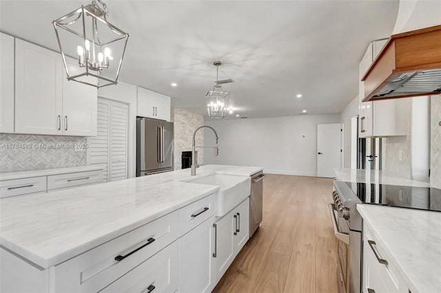 kitchen featuring a notable chandelier, tasteful backsplash, premium appliances, and white cabinetry
