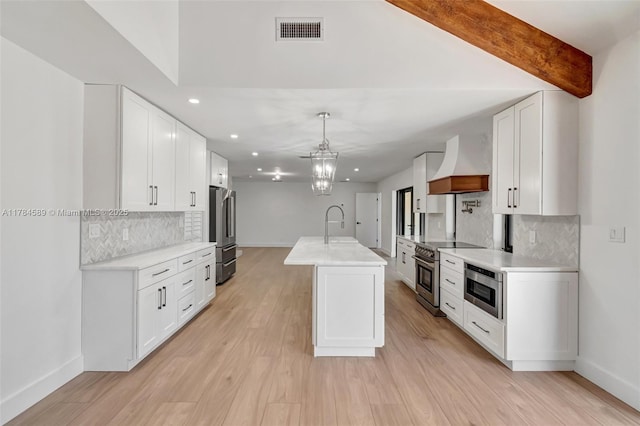 kitchen with visible vents, baseboards, custom exhaust hood, and appliances with stainless steel finishes