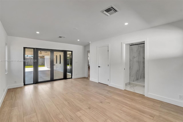 unfurnished room featuring baseboards, visible vents, and light wood-style flooring