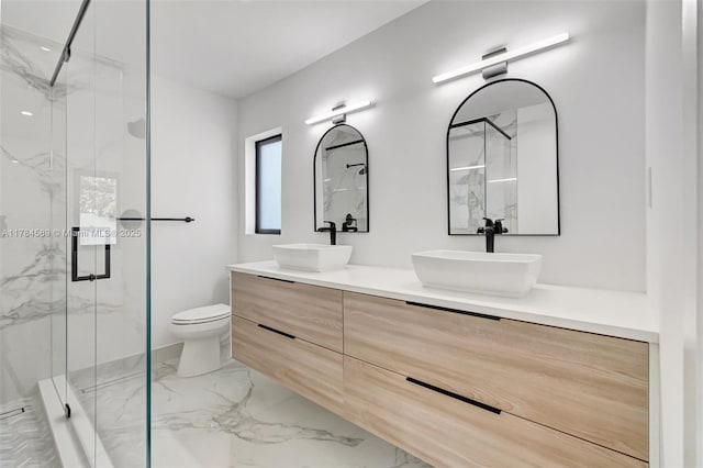 bathroom with marble finish floor, toilet, a sink, and a marble finish shower