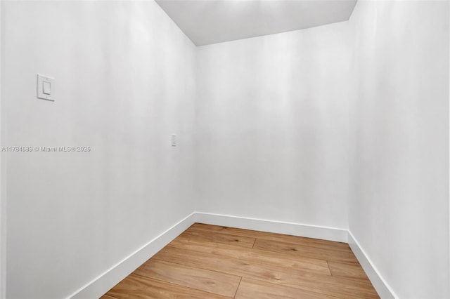 spare room featuring light wood-type flooring and baseboards