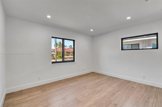 empty room featuring recessed lighting, light wood finished floors, and baseboards