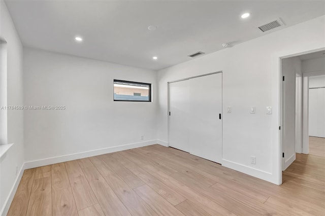 unfurnished bedroom with baseboards, visible vents, and light wood-style flooring