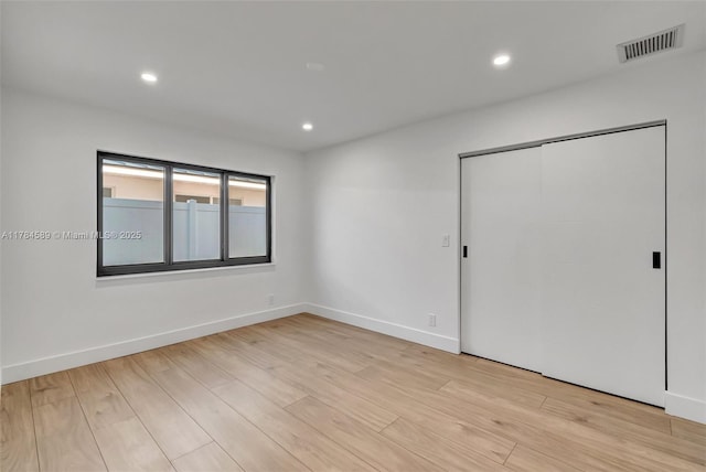 empty room with recessed lighting, light wood-style floors, and visible vents