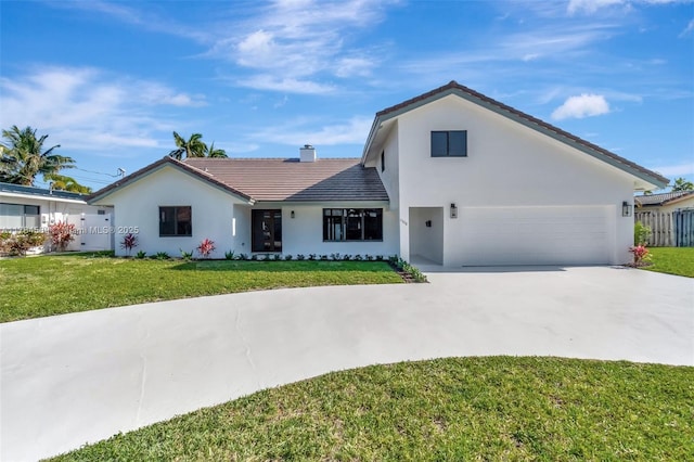 ranch-style home featuring a chimney, a front lawn, concrete driveway, a tile roof, and a garage