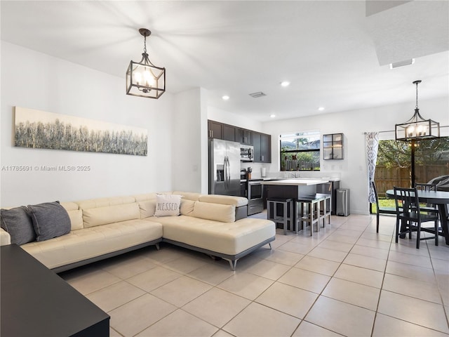 living area with visible vents, recessed lighting, a notable chandelier, and light tile patterned floors