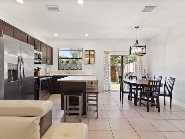 dining area featuring a healthy amount of sunlight, a chandelier, and visible vents