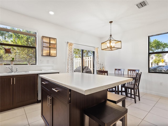 kitchen featuring light countertops, a healthy amount of sunlight, a sink, and light tile patterned flooring