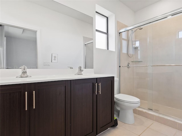 bathroom with tile patterned flooring, double vanity, a shower stall, and toilet