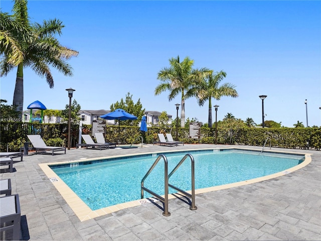 pool with fence and a patio area