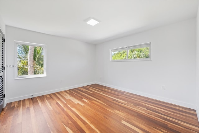 unfurnished room featuring baseboards and light wood-type flooring