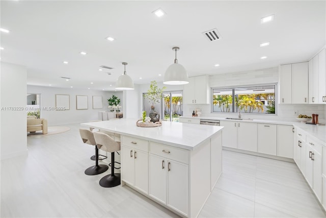 kitchen with backsplash, dishwasher, white cabinets, open floor plan, and recessed lighting