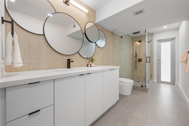 full bath with toilet, vanity, a stall shower, and baseboards