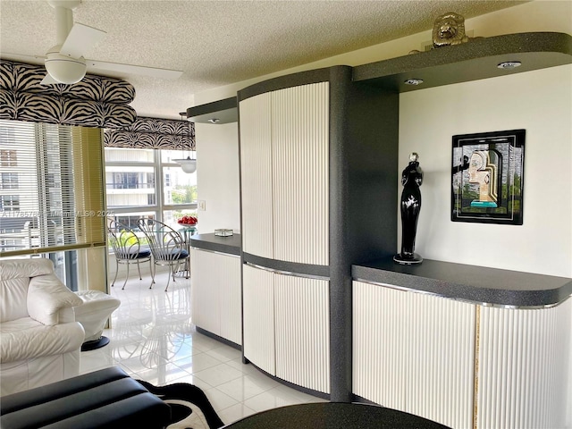 19101 NE 36th Ct Unit 807, Aventura, FL 33180 - kitchen featuring white cabinets, dark countertops, a textured ceiling, and light tile patterned floors