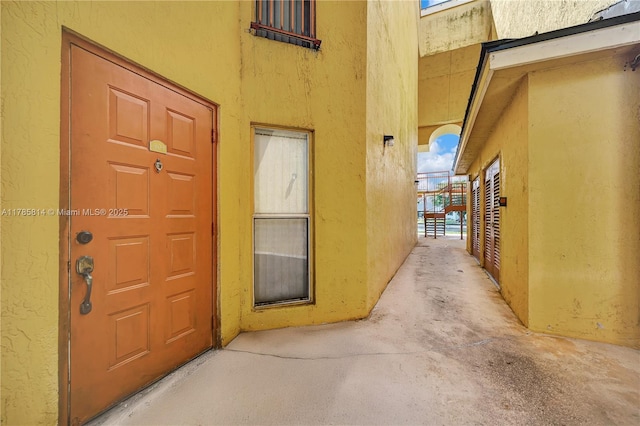 property entrance with stucco siding