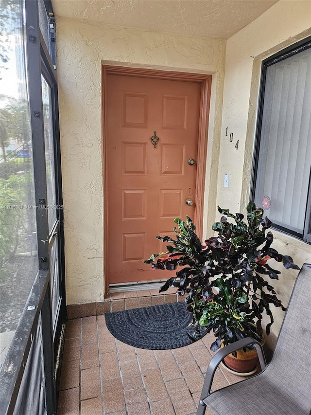 entrance to property featuring stucco siding