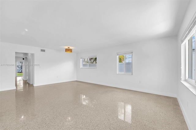 empty room with visible vents and baseboards