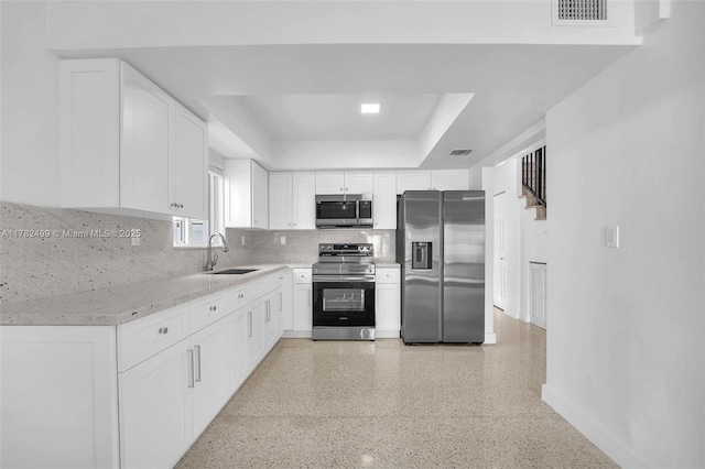 kitchen featuring a raised ceiling, visible vents, stainless steel appliances, and a sink
