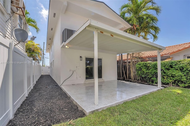 rear view of house featuring stucco siding, a patio, and a fenced backyard