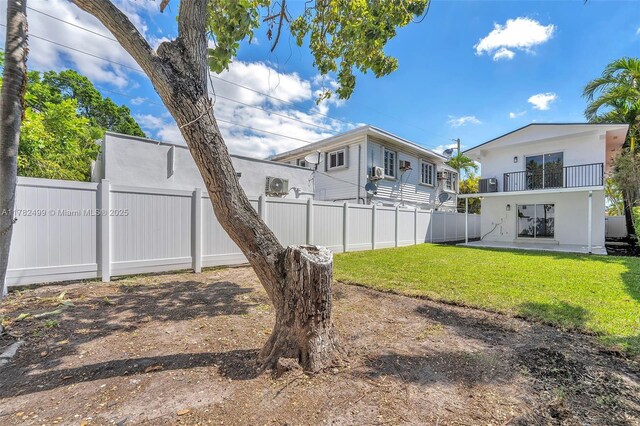 view of yard with fence, a balcony, and a patio